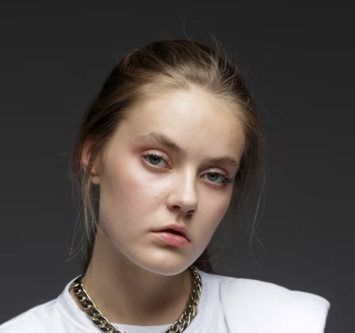 Young woman with serious expression on dark background